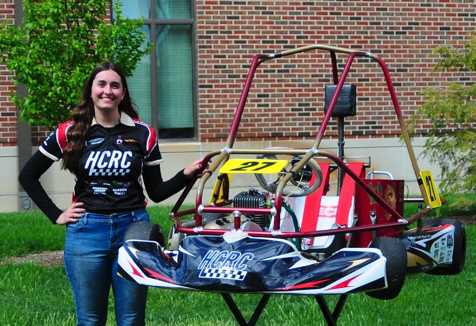 Annalise standing with the Purdue Honors College Racing Crew kart